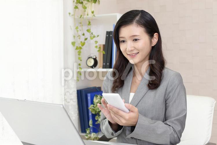 スマートフォンを持つ笑顔のビジネスウーマン 女性,ビジネスウーマン,女の写真素材