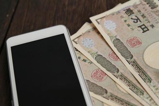 スマホと日本円の札 スマホと日本円の札 スマホ,携帯電話,日本円の写真素材