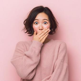 鮮やかなピンクを背景に驚く女性の表情 鮮やかなピンクを背景に驚く女性の表情の写真