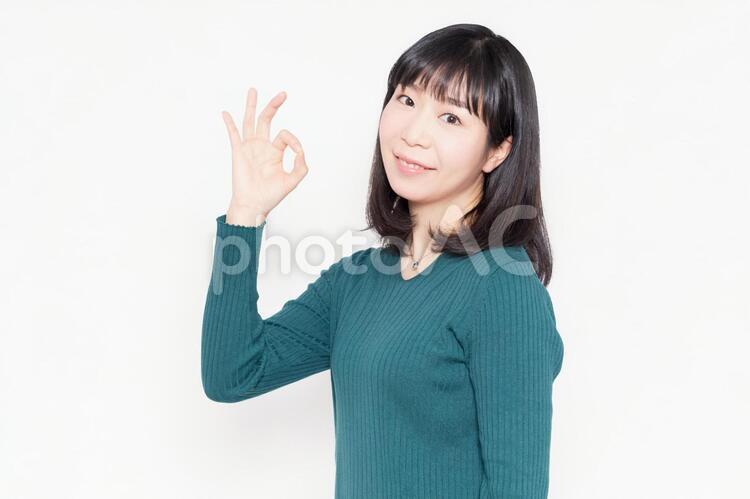 白背景の前に立ってOKのジェスチャーをする女性 女性,ビジネス,okの写真素材
