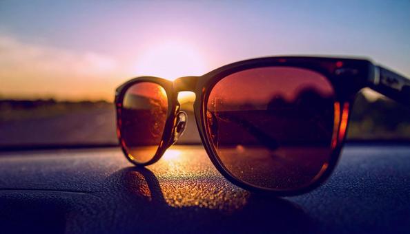 車のダッシュボードに置かれたサングラス 車のダッシュボードに置かれたサングラスの写真