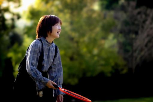 <人物>秋の公園でラケットで遊ぶ女性 <人物>秋の公園でラケットで遊ぶ女性 女性,笑顔,テニスの写真素材