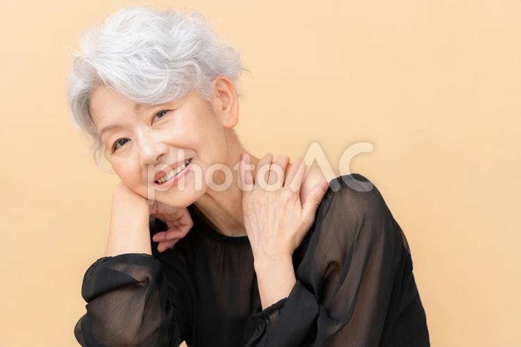 ベージュバックでスキンケアをするシニア ビューティー,女性,シニアの写真素材