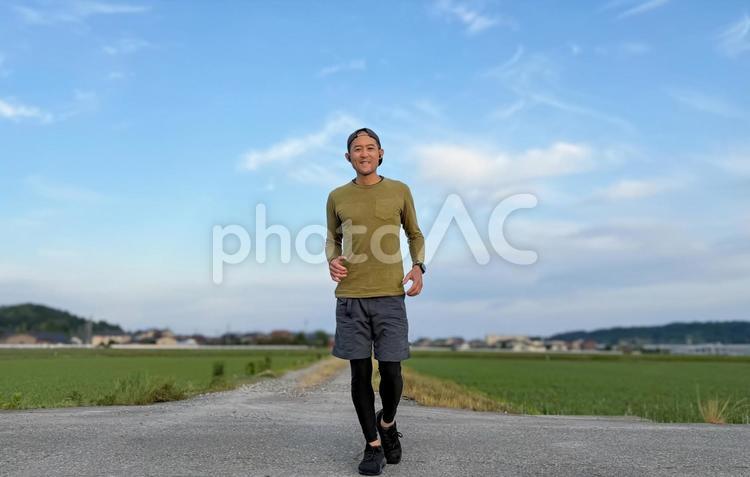 朝の田園でランニングするだ男性 ジョギング,ランニング,男性の写真素材