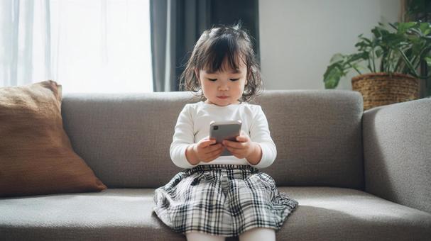 スマートフォンの画面を見ている女の子の写真