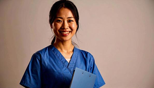 ファイルを抱える笑顔の日本人女性看護師の写真