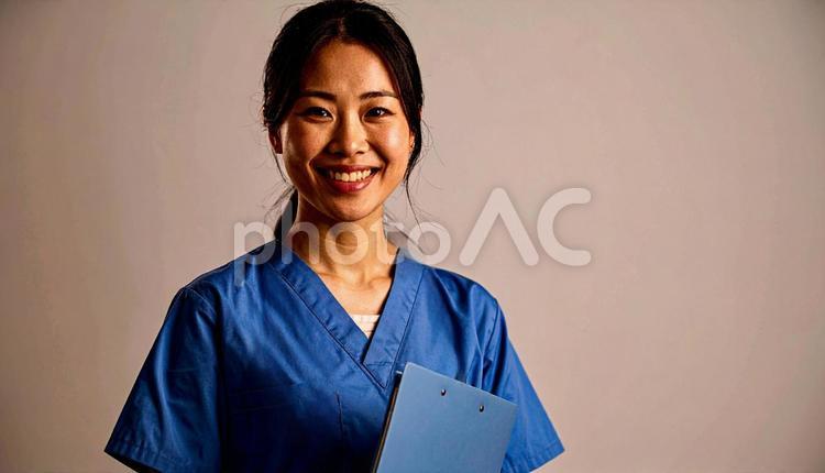 ファイルを抱える笑顔の日本人女性看護師 看護士,若い,白衣の写真素材