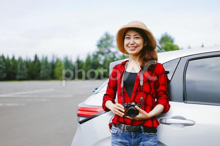 車とカメラを持つ女性 カメラ,旅,一眼レフの写真素材