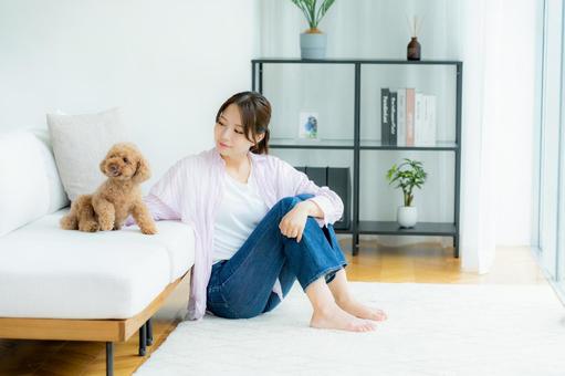 部屋でペットとくつろぐ若い女性 部屋でペットとくつろぐ若い女性 ペット,女性,犬の写真素材