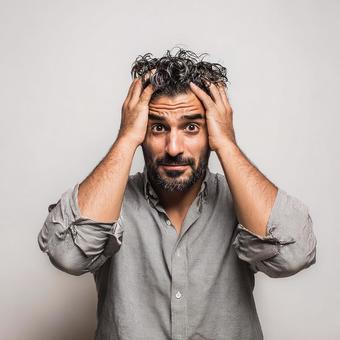 焦りや失敗を表現する、髭の男性の写真