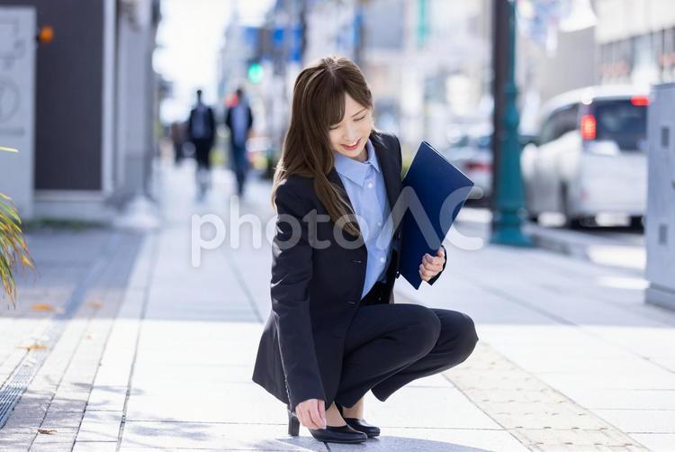 スーツを着てしゃがむ女性　 女性,ビジネス,スーツの写真素材