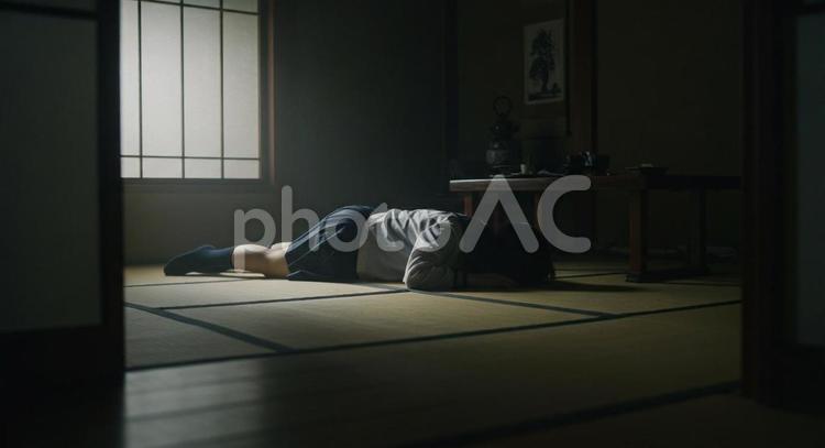 畳の上にうつ伏せになる女性（ヒキ） ホラー,影,畳の写真素材