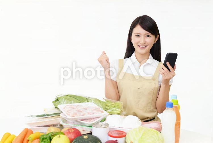 スマートフォンを持つ笑顔の主婦 女性,主婦,笑顔の写真素材