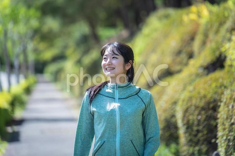 緑の中でウォーキングする女性 ウォーキング,有酸素運動,歩くの写真素材