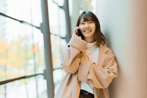 スマホで通話をするコートを着た女性 女性,人物,秋の写真素材