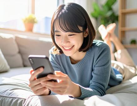 ソファでスマホを見る女性8 ソファでスマホを見る女性8の写真
