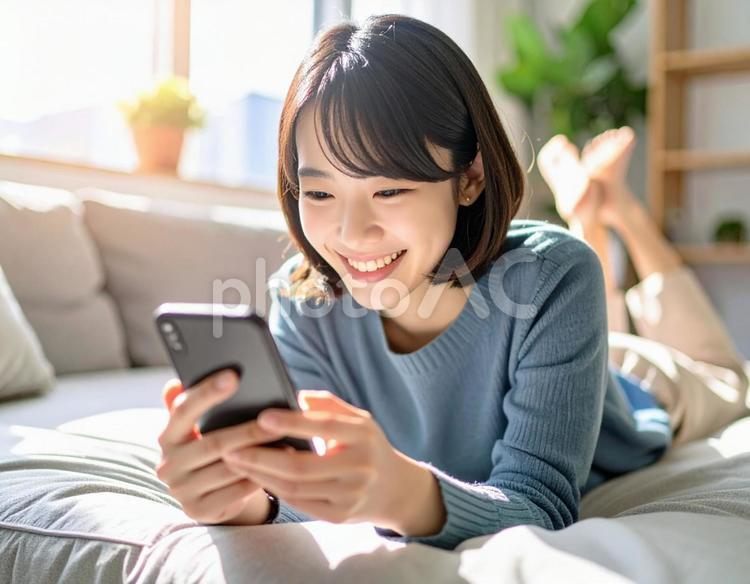 ソファでスマホを見る女性8 スマートフォン,スマホ,女性の写真素材