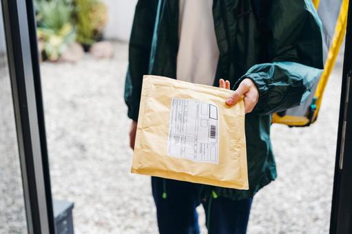 クッション封筒を届けに来た配達員 配達,デリバリー,配送の写真素材