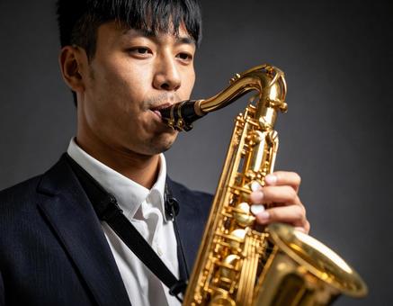 バリトンサックスを演奏する男性 バリトンサックスを演奏する男性の写真