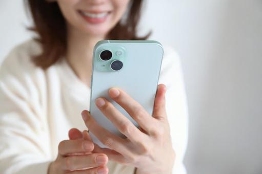 スマートフォンを見る女性 ビデオ通話,テレビ電話,スマホの写真素材