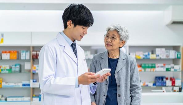 穏やかに話している薬剤師と高齢者 穏やかに話している薬剤師と高齢者の写真