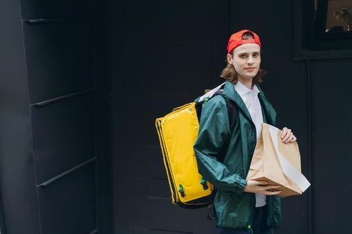 紙袋を届けに来た配達員 配達,フードデリバリー,デリバリーの写真素材