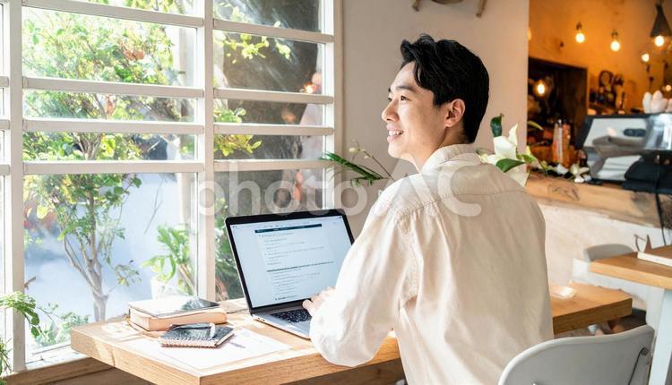 カフェで仕事をするフリーランス男性 男性,コワーキングスペース,コワーキングの写真素材