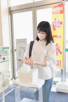 スーパーの入り口で消毒する女性 スーパーの入り口で消毒する女性 スーパー,女性,日本人の写真素材