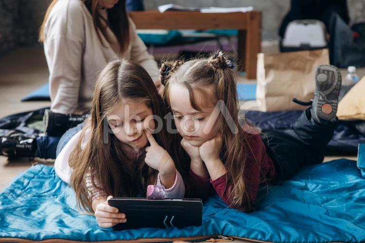 考える女の子とタブレットを見る女の子 女の子,人物,貧困の写真素材