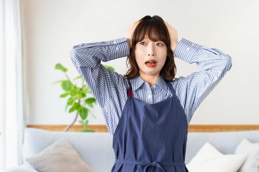 頭を抱えて悩むエプロン姿の女性 頭を抱えて悩むエプロン姿の女性 女性,悩む,エプロンの写真素材