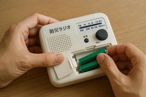 防災ラジオの電池を入れ替える手元 防災ラジオの電池を入れ替える手元の写真