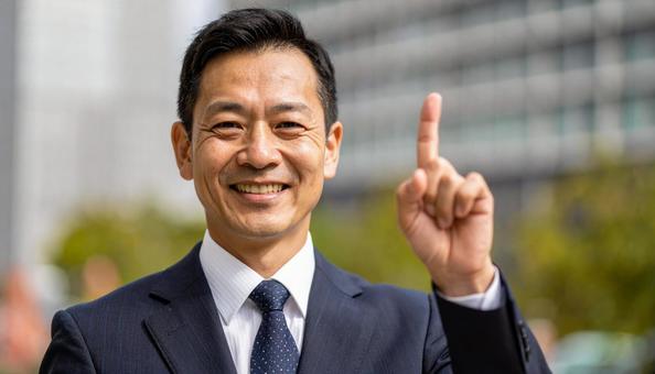 都市背景で人差し指を立てるビジネスマンの写真