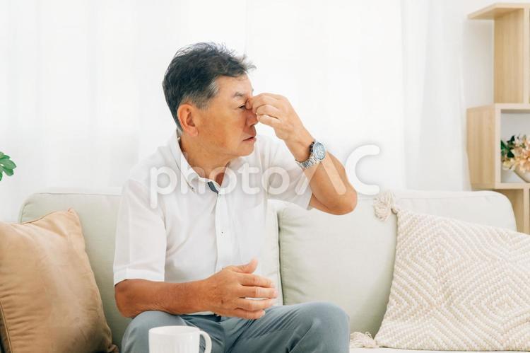 家にいる高齢者の男性（鼻・眼精疲労） 鼻水,鼻詰まり,高齢者の写真素材