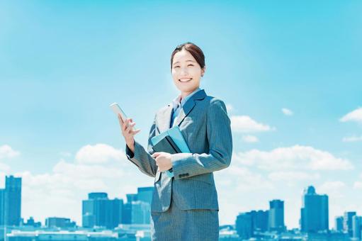 A smiling business woman with a smartphone in her hand A smiling business woman with a smartphone in her hand