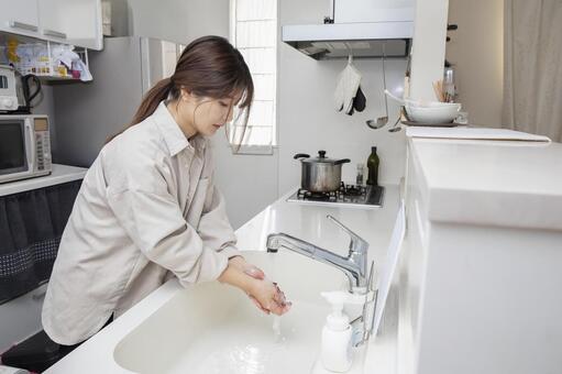 キッチンで手を洗う女性 女性,キッチン,手洗いの写真素材