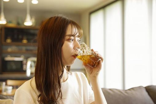 笑顔でアイスティーを飲む女性 笑顔でアイスティーを飲む女性 女性,若い,笑顔の写真素材