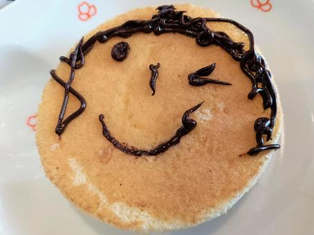 チョコペンで子供が描いたパンケーキ チョコペンで子供が描いたパンケーキの写真