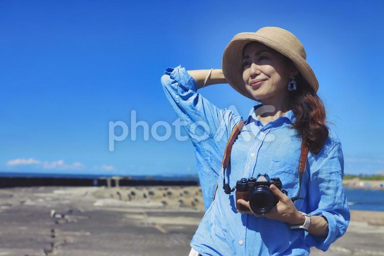 カメラを持って微笑む女性 カメラ,一眼レフ,旅の写真素材