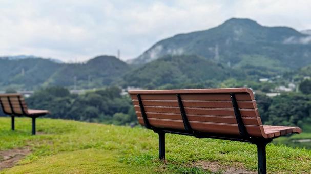 緑の丘に佇む、静かなベンチの風景 緑の丘に佇む、静かなベンチの風景の写真
