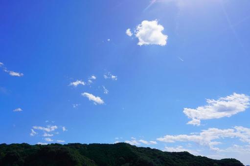 青空と山と太陽の光・背景素材 夏空,青空,太陽の写真素材