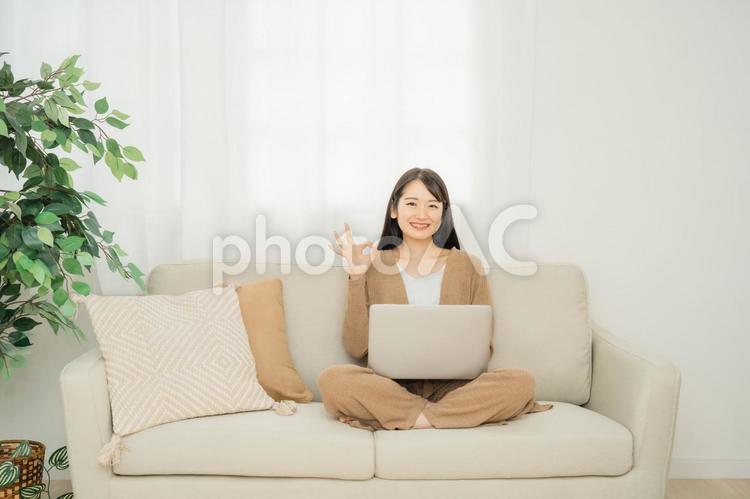 家でノートパソコンを使う女性（ソファ） パソコン,女性,ソファの写真素材