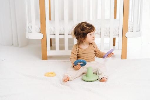 両手に玩具の輪を持ち座る子 両手に玩具の輪を持ち座る子 赤ちゃん,かわいい,お座りの写真素材