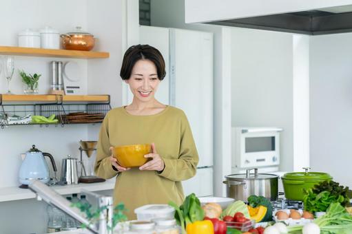 キッチンで調理するミドルの主婦 キッチンで調理するミドルの主婦の写真