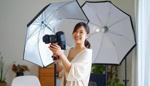 写真撮影を行う20代の女性カメラマン 写真撮影を行う20代の女性カメラマンの写真