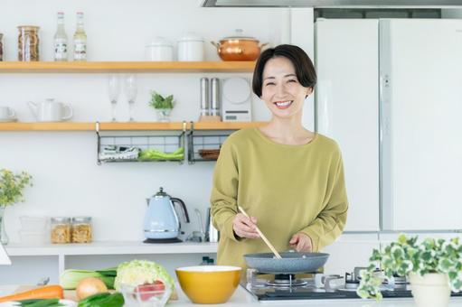 調理するミドルの主婦 調理するミドルの主婦の写真