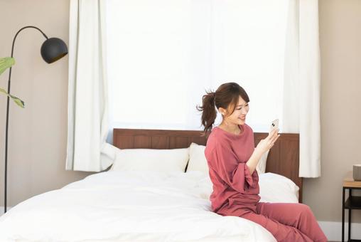 ベッドでくつろぐ女性 ベッドでくつろぐ女性の写真