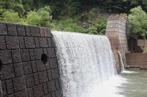 川の流れを調整する人工的な横に長い滝 水,放流,調整の写真素材