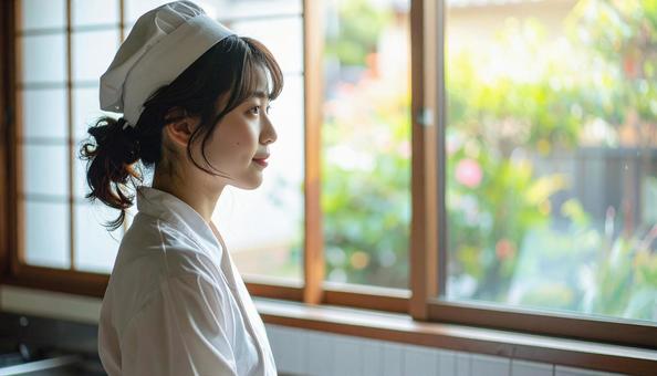 レストランの調理場で料理するスタッフ女性 レストランの調理場で料理するスタッフ女性の写真