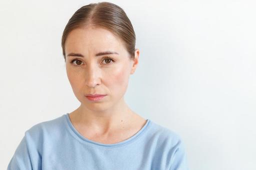 水色のカットソーを着た上目遣いの女性 女性,外国人,欧米人の写真素材