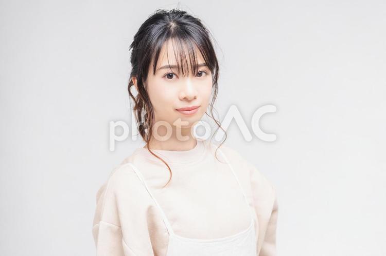 白い背景の前に立ってポーズをとる若い女性 女性,白背景,立つの写真素材